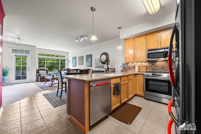 7655 Stepping Stone Ln Unit Q2, Anchorage, AK 99504 - kitchen with stainless steel appliances, open floor plan, a peninsula, decorative backsplash, and hanging light fixtures