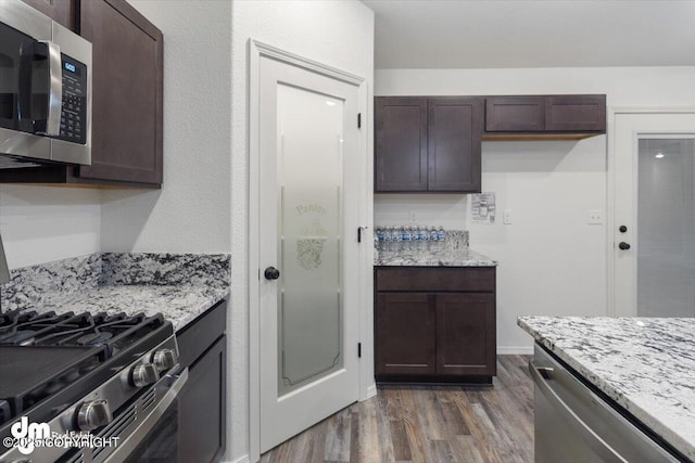 4125 E Zircon Cir, Wasilla, AK 99654 - kitchen featuring stainless steel appliances, dark wood-style flooring, dark brown cabinetry, and light stone counters