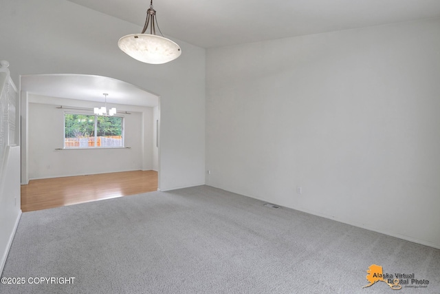 2321 Lusardi Point Cir, Anchorage, AK 99515 - empty room with carpet flooring, a chandelier, and arched walkways