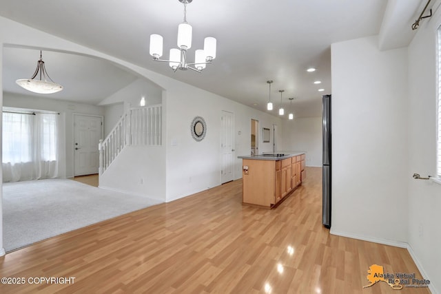 2321 Lusardi Point Cir, Anchorage, AK 99515 - kitchen with arched walkways, light wood finished floors, open floor plan, a chandelier, and a kitchen island with sink