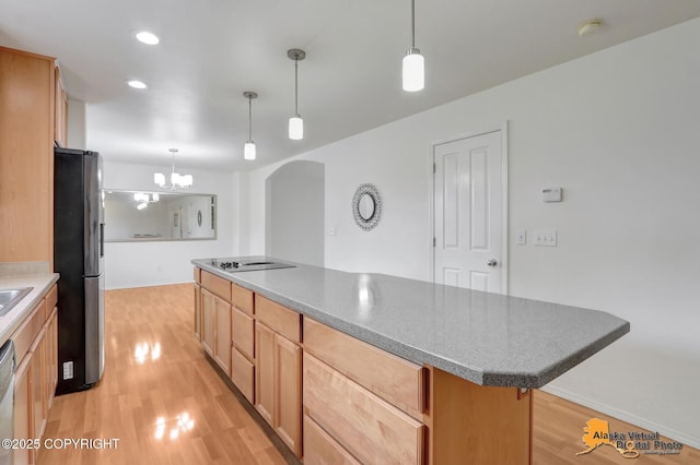 2321 Lusardi Point Cir, Anchorage, AK 99515 - kitchen featuring freestanding refrigerator, black electric stovetop, light wood-style flooring, arched walkways, and a kitchen island