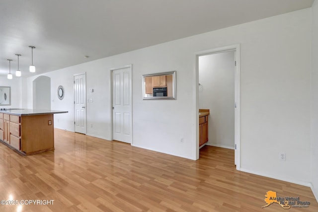 2321 Lusardi Point Cir, Anchorage, AK 99515 - kitchen with light wood finished floors, arched walkways, hanging light fixtures, and a center island