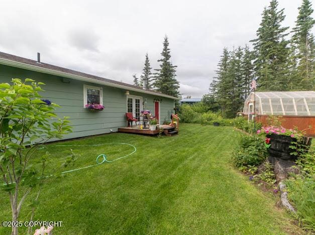 282 Marydale Ct, Soldotna, AK 99669 - view of green lawn with a deck, an exterior structure, and an outbuilding