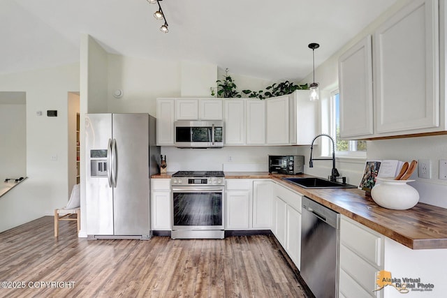 14795 E Hearthstone Dr, Palmer, AK 99645 - kitchen with stainless steel appliances, wood counters, vaulted ceiling, light wood-style flooring, and white cabinets