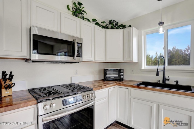 14795 E Hearthstone Dr, Palmer, AK 99645 - kitchen with appliances with stainless steel finishes, butcher block countertops, white cabinets, and hanging light fixtures