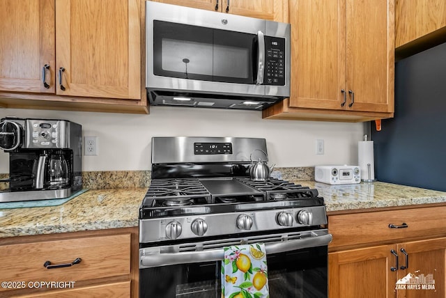 23011 Sherman St # 24, Chugiak, AK 99567 - kitchen with stainless steel appliances, light stone counters, and brown cabinets