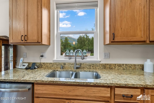 23011 Sherman St # 24, Chugiak, AK 99567 - kitchen featuring stainless steel dishwasher, light stone countertops, and brown cabinetry