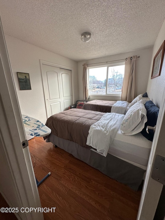 2541 Lyvona Ln, Anchorage, AK 99502 - bedroom featuring wood finished floors, a textured ceiling, and a closet