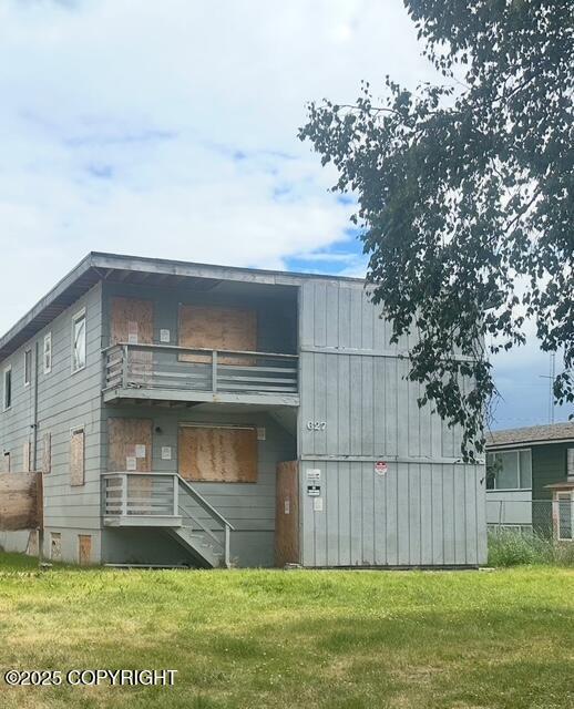 627 N Flower St, Anchorage, AK 99508 - rear view of house featuring a balcony and a yard