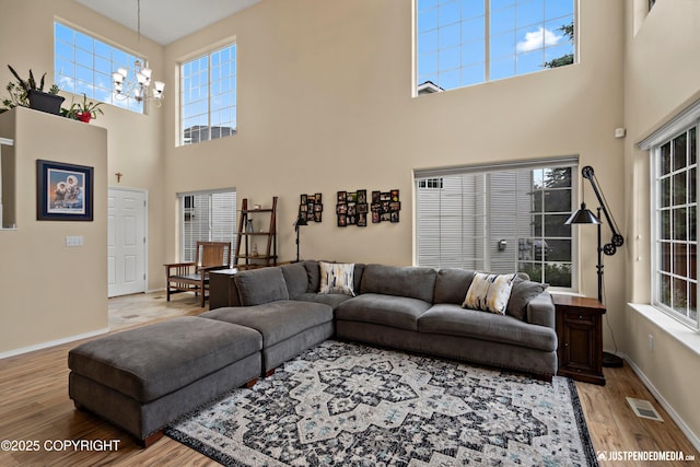 2431 Harbor Landing Cir, Anchorage, AK 99515 - living room featuring light wood finished floors, a towering ceiling, and a chandelier