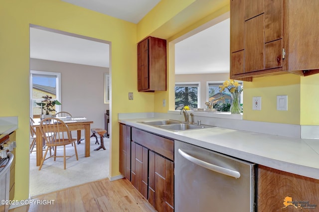 1854 Buccaneer Pl, Anchorage, AK 99501 - kitchen with stainless steel dishwasher, light wood-style flooring, light countertops, and brown cabinets