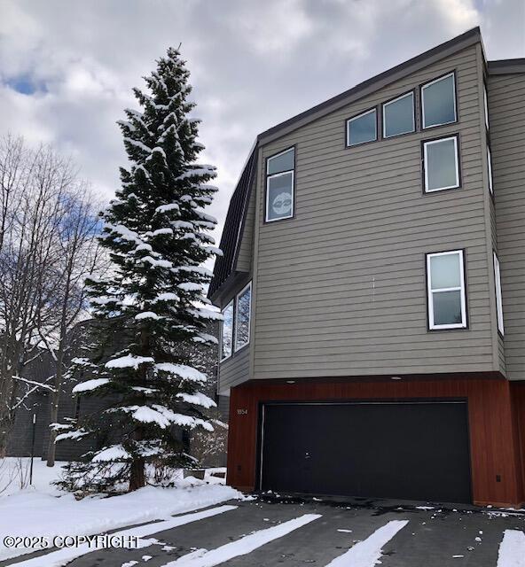 1854 Buccaneer Pl, Anchorage, AK 99501 - view of snow covered exterior featuring an attached garage