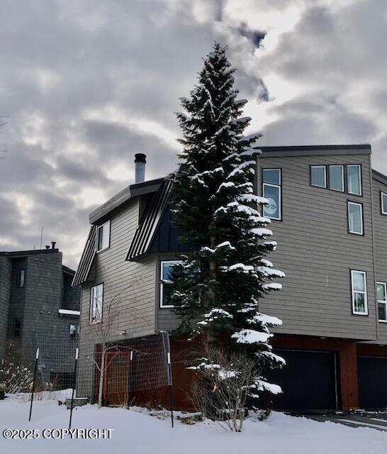 1854 Buccaneer Pl, Anchorage, AK 99501 - view of snowy exterior featuring an attached garage