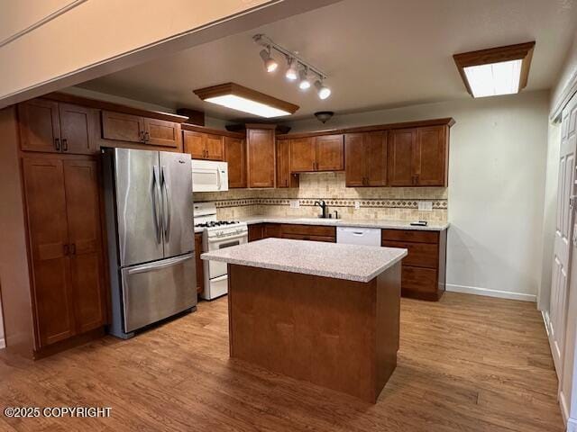 950 E Chugach View Dr, Wasilla, AK 99654 - kitchen featuring white appliances, decorative backsplash, light wood finished floors, and a center island