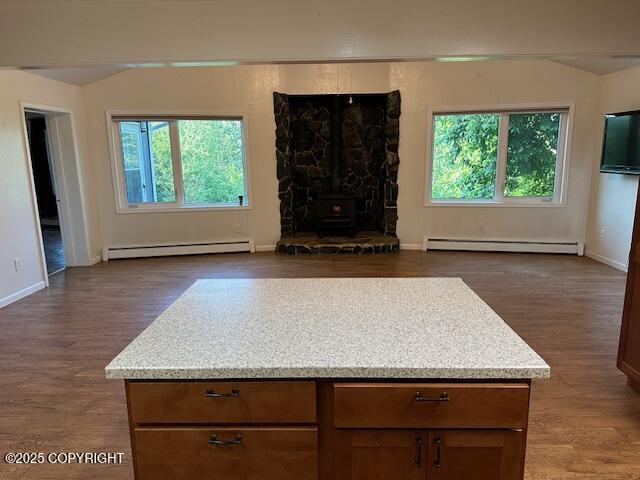 950 E Chugach View Dr, Wasilla, AK 99654 - unfurnished living room featuring baseboard heating, a wood stove, and dark wood-style flooring