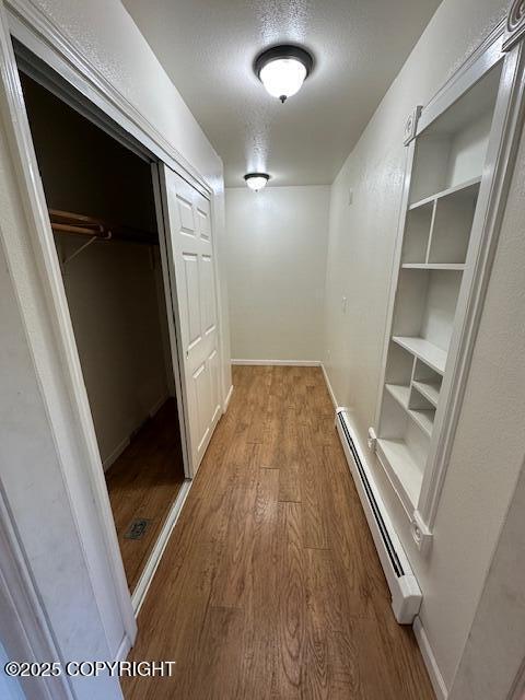 950 E Chugach View Dr, Wasilla, AK 99654 - hallway featuring a baseboard radiator, wood finished floors, and built in features