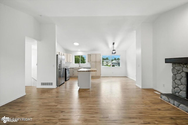 1250 W Josselin Ln, Palmer, AK 99645 - kitchen featuring stainless steel appliances, open floor plan, wood finished floors, light countertops, and a center island