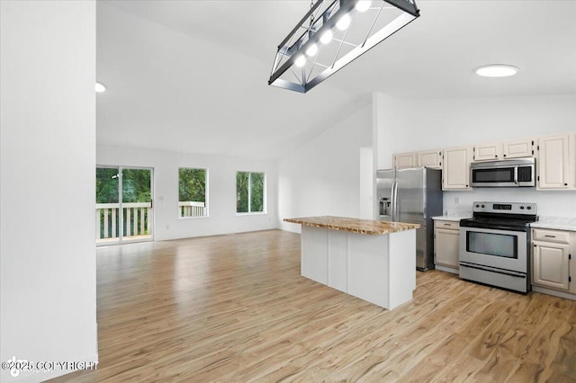 1250 W Josselin Ln, Palmer, AK 99645 - kitchen with stainless steel appliances, open floor plan, light wood finished floors, a center island, and high vaulted ceiling