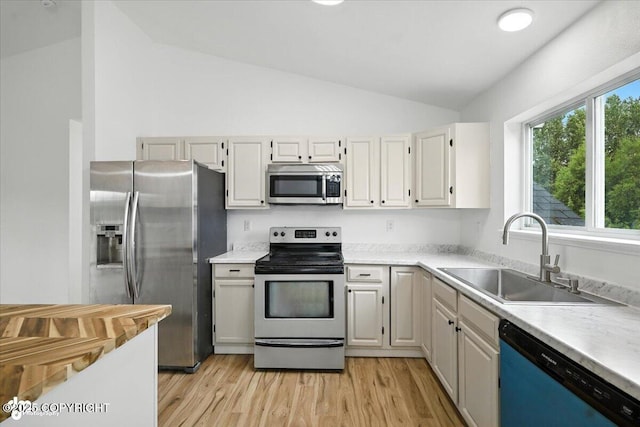 1250 W Josselin Ln, Palmer, AK 99645 - kitchen featuring appliances with stainless steel finishes, lofted ceiling, light countertops, and light wood finished floors
