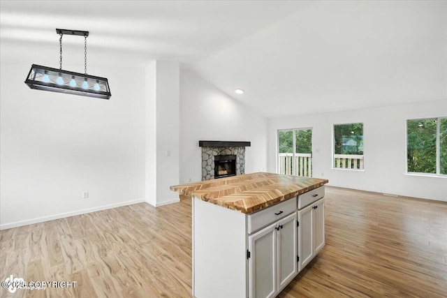 1250 W Josselin Ln, Palmer, AK 99645 - kitchen with open floor plan, butcher block countertops, white cabinets, light wood finished floors, and a stone fireplace