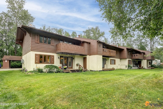 4840 Bryn Mawr Ct Unit 3, Anchorage, AK 99508 - back of house featuring a balcony, a yard, stucco siding, and a chimney