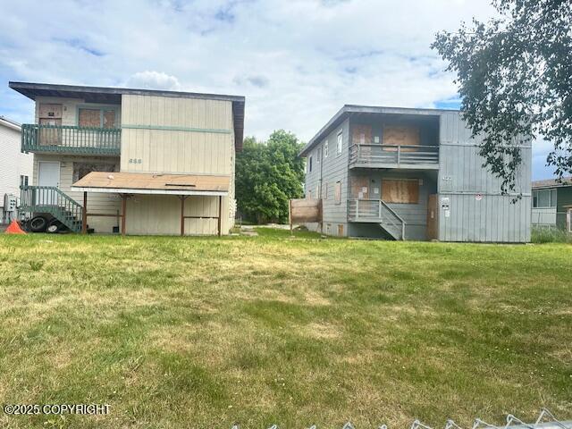 633 N Flower St, Anchorage, AK 99508 - back of property with a balcony, stairway, and a yard
