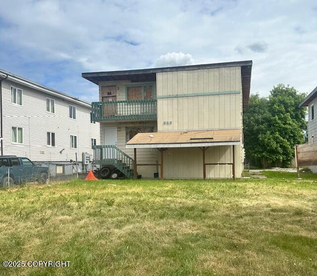 633 N Flower St, Anchorage, AK 99508 - rear view of house with a lawn and a balcony