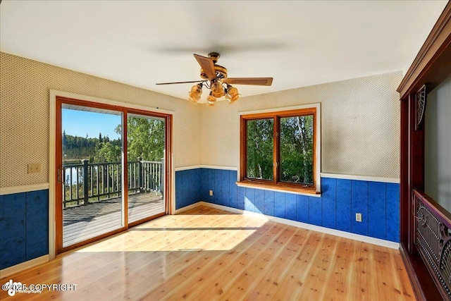 43725 Ross Dr, Soldotna, AK 99669 - unfurnished room with wood finished floors, wainscoting, plenty of natural light, a ceiling fan, and wallpapered walls