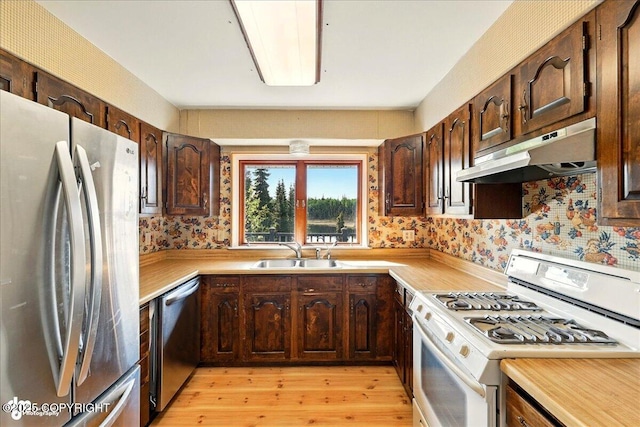 43725 Ross Dr, Soldotna, AK 99669 - kitchen featuring stainless steel appliances, under cabinet range hood, light countertops, light wood-style floors, and dark brown cabinets