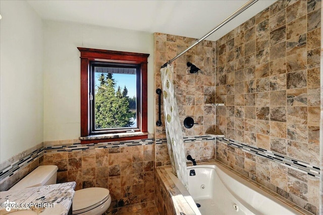 43725 Ross Dr, Soldotna, AK 99669 - bathroom featuring tile walls, a combined bath / shower with jetted tub, vanity, and wainscoting