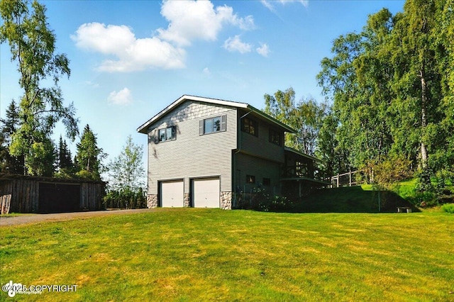 43725 Ross Dr, Soldotna, AK 99669 - back of property with an attached garage, stone siding, a lawn, and driveway