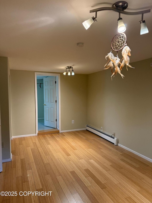2090 Dimond Dr, Anchorage, AK 99507 - spare room with a baseboard radiator, light wood-type flooring, a chandelier, and a smoke detector