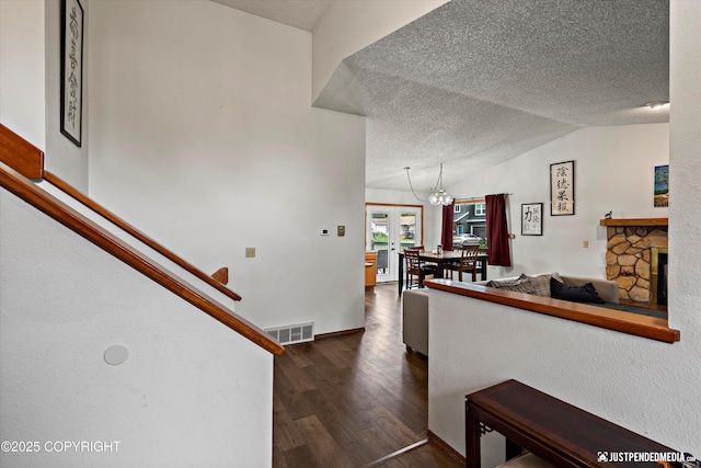 260 N Gloria St, Palmer, AK 99645 - staircase featuring a textured ceiling, wood finished floors, lofted ceiling, a chandelier, and a stone fireplace