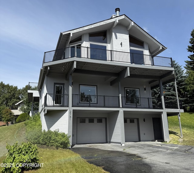 2751 Pelican Dr, Anchorage, AK 99502 - view of front of property featuring a balcony, a garage, and driveway