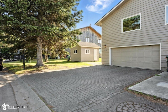 2350 Canary Ct, Anchorage, AK 99515 - view of home's exterior featuring driveway, a garage, and a lawn