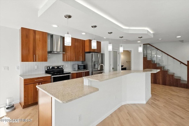 2350 Canary Ct, Anchorage, AK 99515 - kitchen featuring appliances with stainless steel finishes, wall chimney exhaust hood, brown cabinets, a spacious island, and recessed lighting