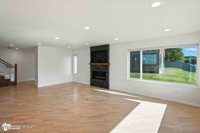 2350 Canary Ct, Anchorage, AK 99515 - unfurnished living room with a large fireplace, recessed lighting, stairs, and light wood-style flooring