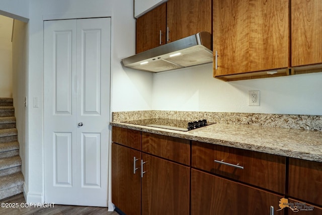 2350 Canary Ct, Anchorage, AK 99515 - kitchen with under cabinet range hood, black electric cooktop, wood finished floors, and light stone counters