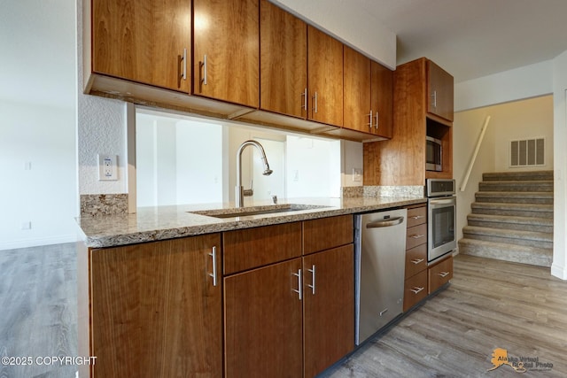 2350 Canary Ct, Anchorage, AK 99515 - kitchen featuring stainless steel appliances, light wood finished floors, and light stone counters