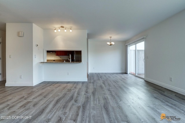 2350 Canary Ct, Anchorage, AK 99515 - unfurnished living room featuring a chandelier and wood finished floors