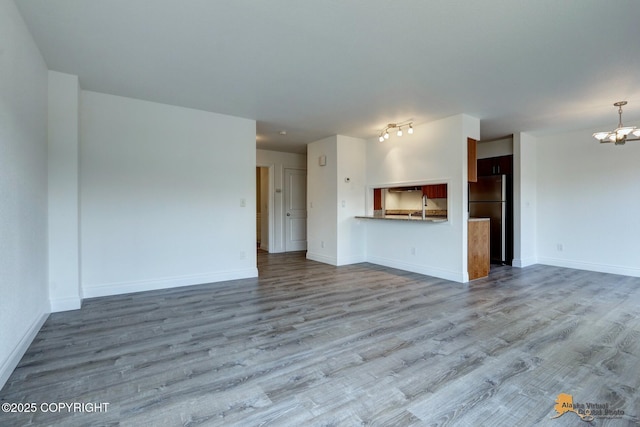 2350 Canary Ct, Anchorage, AK 99515 - unfurnished living room featuring a chandelier and wood finished floors