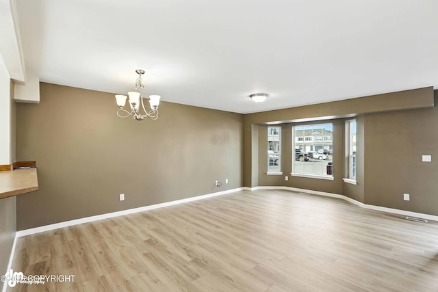 133 Matthew Paul Way, Anchorage, AK 99504 - empty room with light wood-style floors and a chandelier