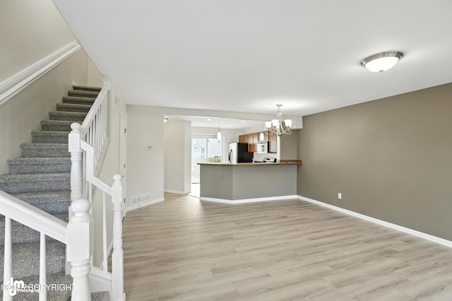 133 Matthew Paul Way, Anchorage, AK 99504 - unfurnished living room featuring a chandelier, light wood-style floors, and stairs