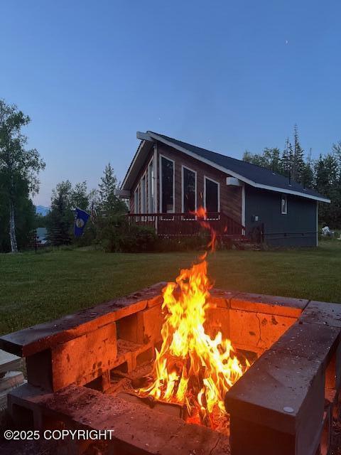 3021 N Arctic Fox Dr, Wasilla, AK 99654 - back of house featuring a fire pit, a yard, and a deck