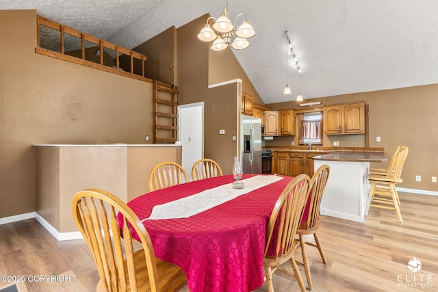 3021 N Arctic Fox Dr, Wasilla, AK 99654 - dining space with a textured ceiling, light wood-type flooring, and high vaulted ceiling