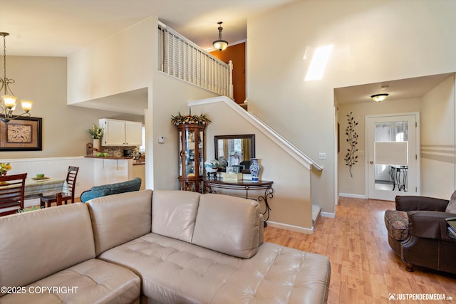 4060 Defiance St, Anchorage, AK 99504 - living room with a chandelier, stairs, light wood-type flooring, and a high ceiling