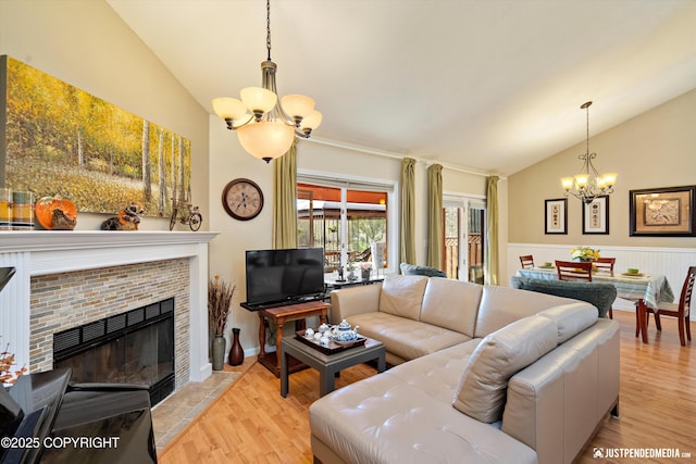 4060 Defiance St, Anchorage, AK 99504 - living room with a chandelier, vaulted ceiling, light wood finished floors, a fireplace, and wainscoting