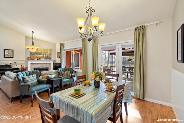 4060 Defiance St, Anchorage, AK 99504 - dining room featuring a chandelier, light wood-style flooring, a fireplace, and lofted ceiling