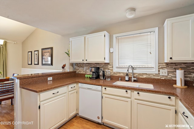 4060 Defiance St, Anchorage, AK 99504 - kitchen with white dishwasher, a peninsula, backsplash, light wood-style flooring, and dark countertops