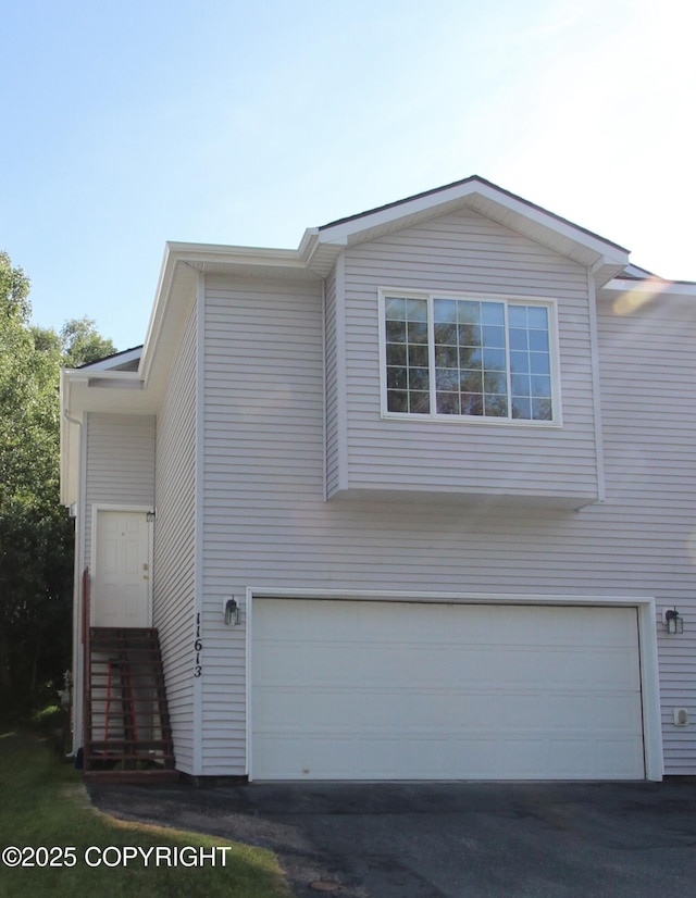 11613 Birch Knoll Loop, Anchorage, AK 99515 - view of property exterior with a garage and asphalt driveway